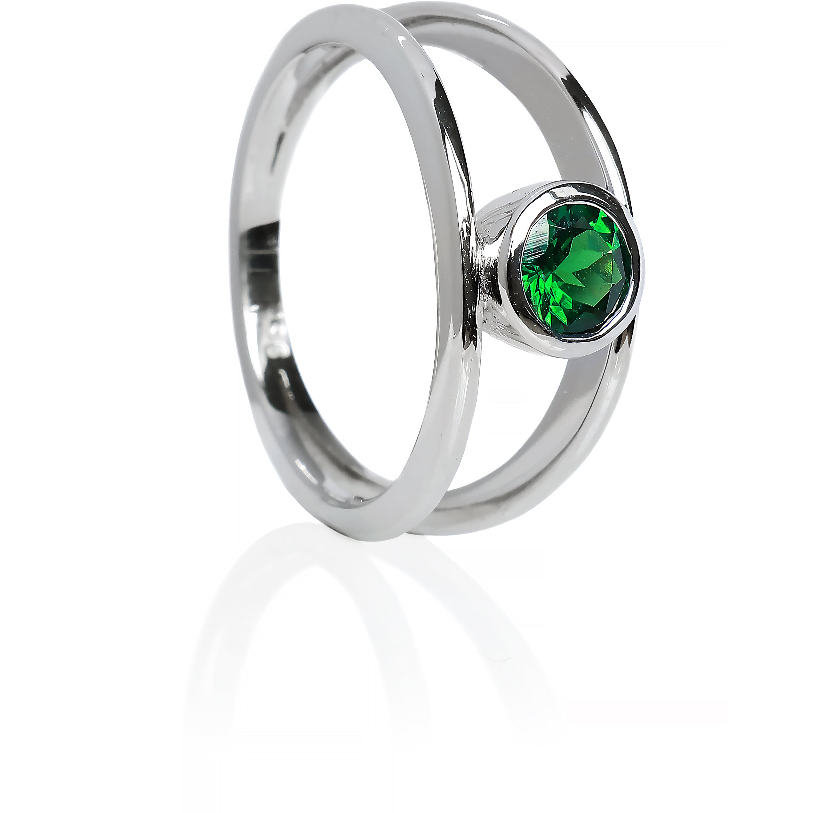 A product photo of a split-band white gold ring with a bezel-set tsavorite centre stone sitting on a white background. The band splits at the base of the ring, separating to meet at the top and bottom of the verdant-green tsavorite centre stone, framed in a thick layer of gold, holding it in place.  The green gemstone colour would be a good emerald substitute.