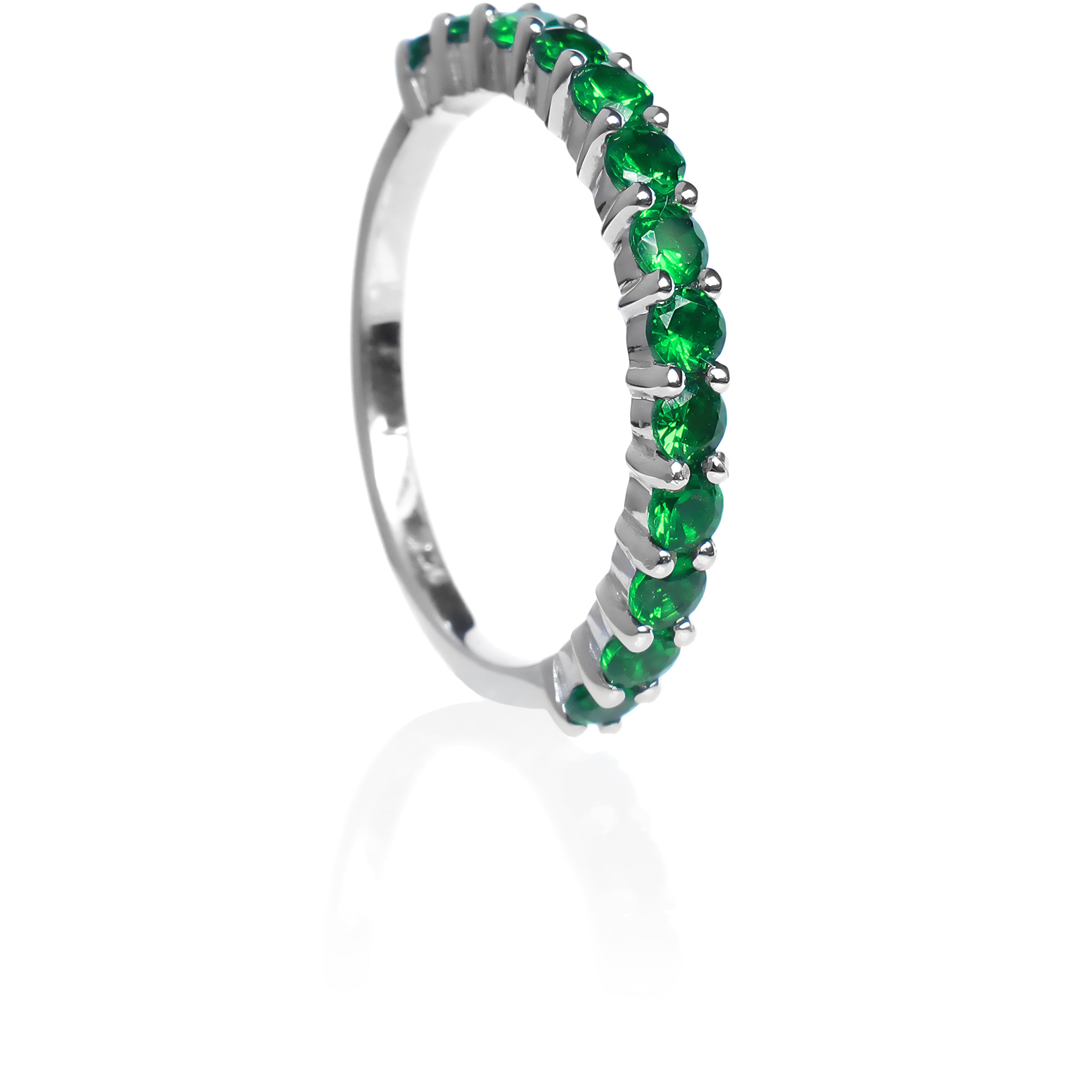 A product photo of a white gold eternity band with 13 tsavorite stones embedded along its length on a white background. The green gemstone colour would be a good emerald substitute.