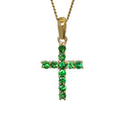 A product photo of a dainty cross pendant delicately bejewelled with electric green tsavorite stones suspended against a white background. The Christian cross pendant is made up of 11 stones in total, which reflect verdant hues from their facets. Perfect for use as a girl's confirmation necklace.