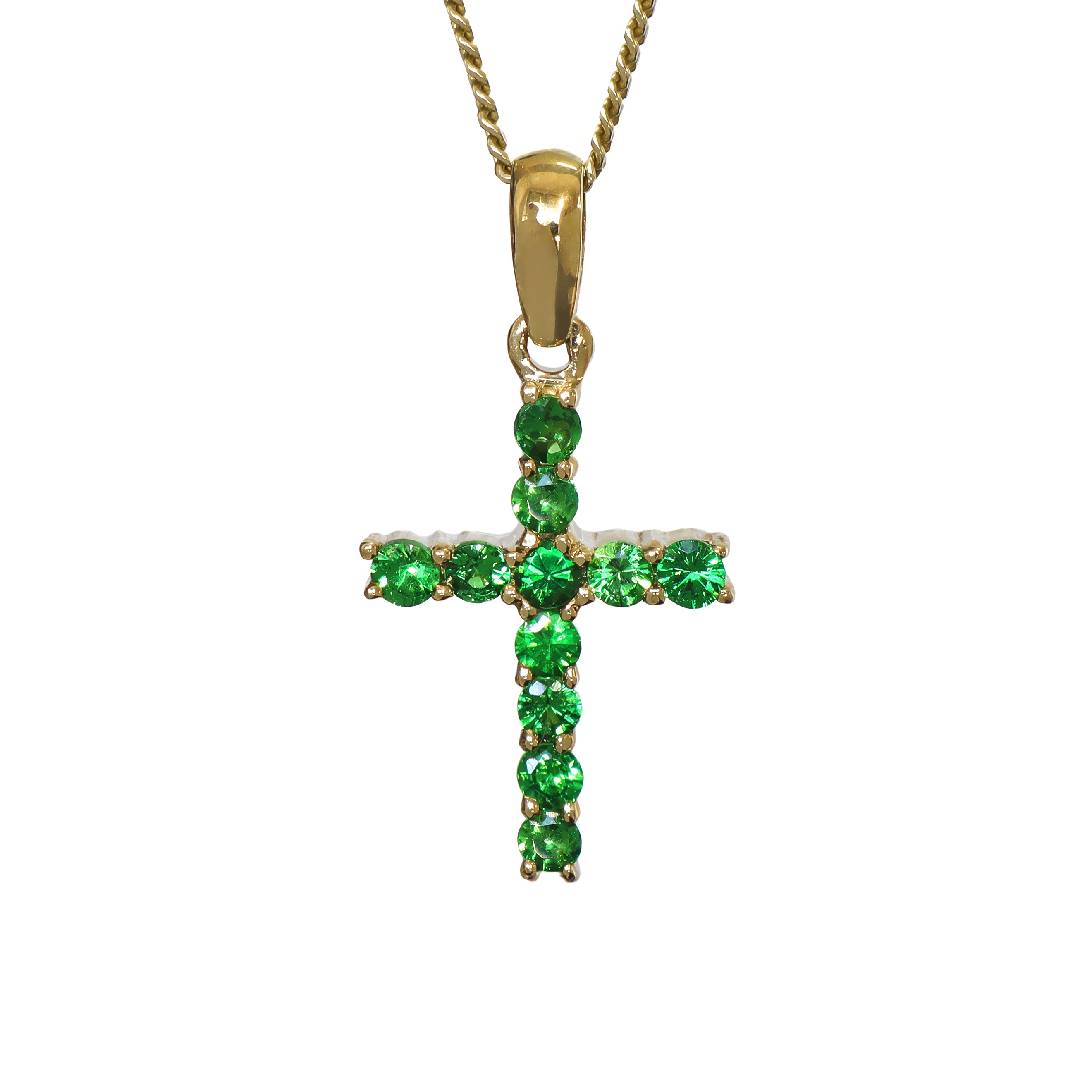 A product photo of a dainty cross pendant delicately bejewelled with electric green tsavorite stones suspended against a white background. The Christian cross pendant is made up of 11 stones in total, which reflect verdant hues from their facets. Perfect for use as a girl's confirmation necklace.