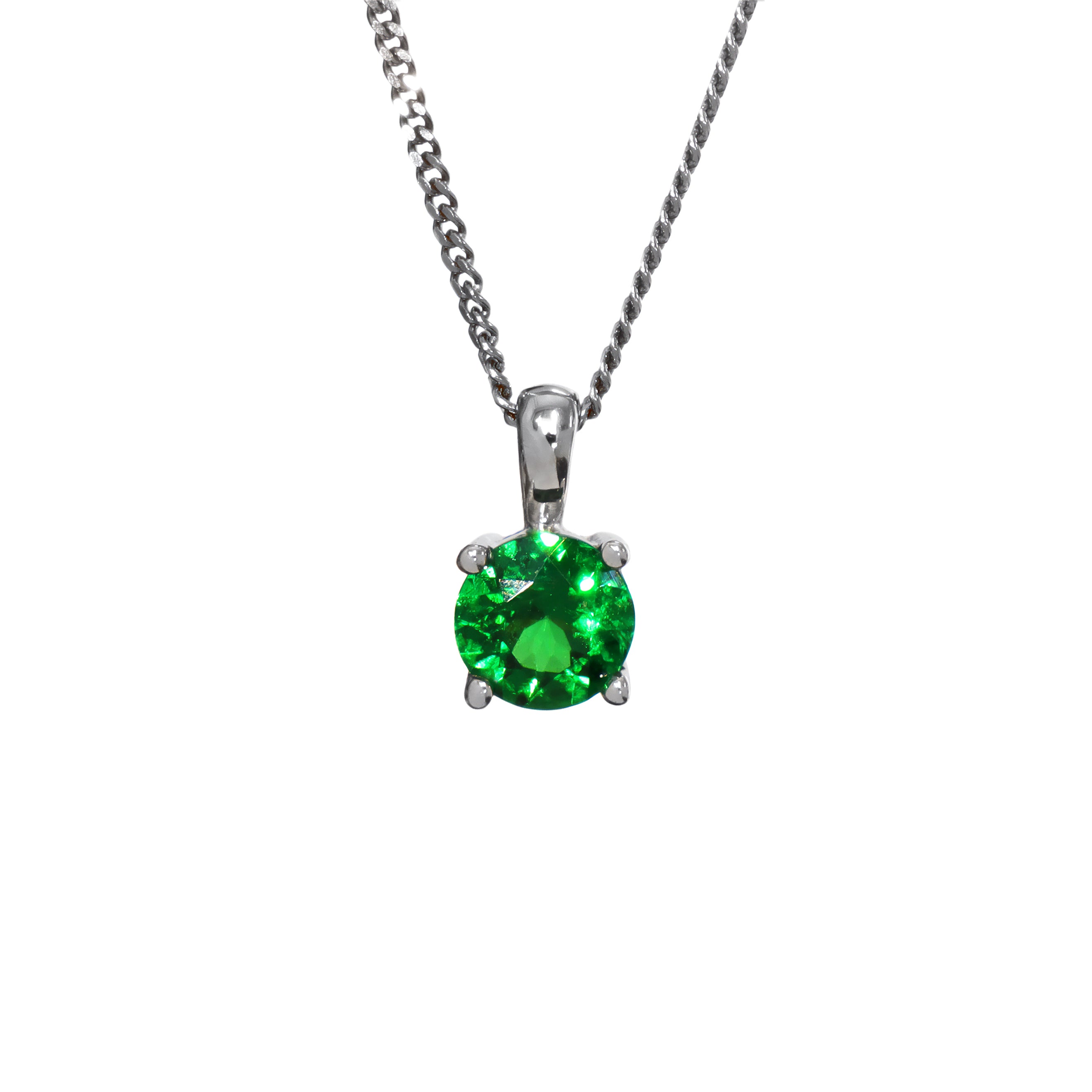 A product photo of a white gold tsavorite pendant suspended by a chain against a white background. The round stone is held in place by 4 small claws, and reflects electric green and verdant colours from its many edges.