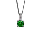 A product photo of a pair of a white gold tsavorite pendant suspended against a white background. The simple circle-cut stone are contrasted by the white diamond trio protruding in a straight line above it, encased in white gold.