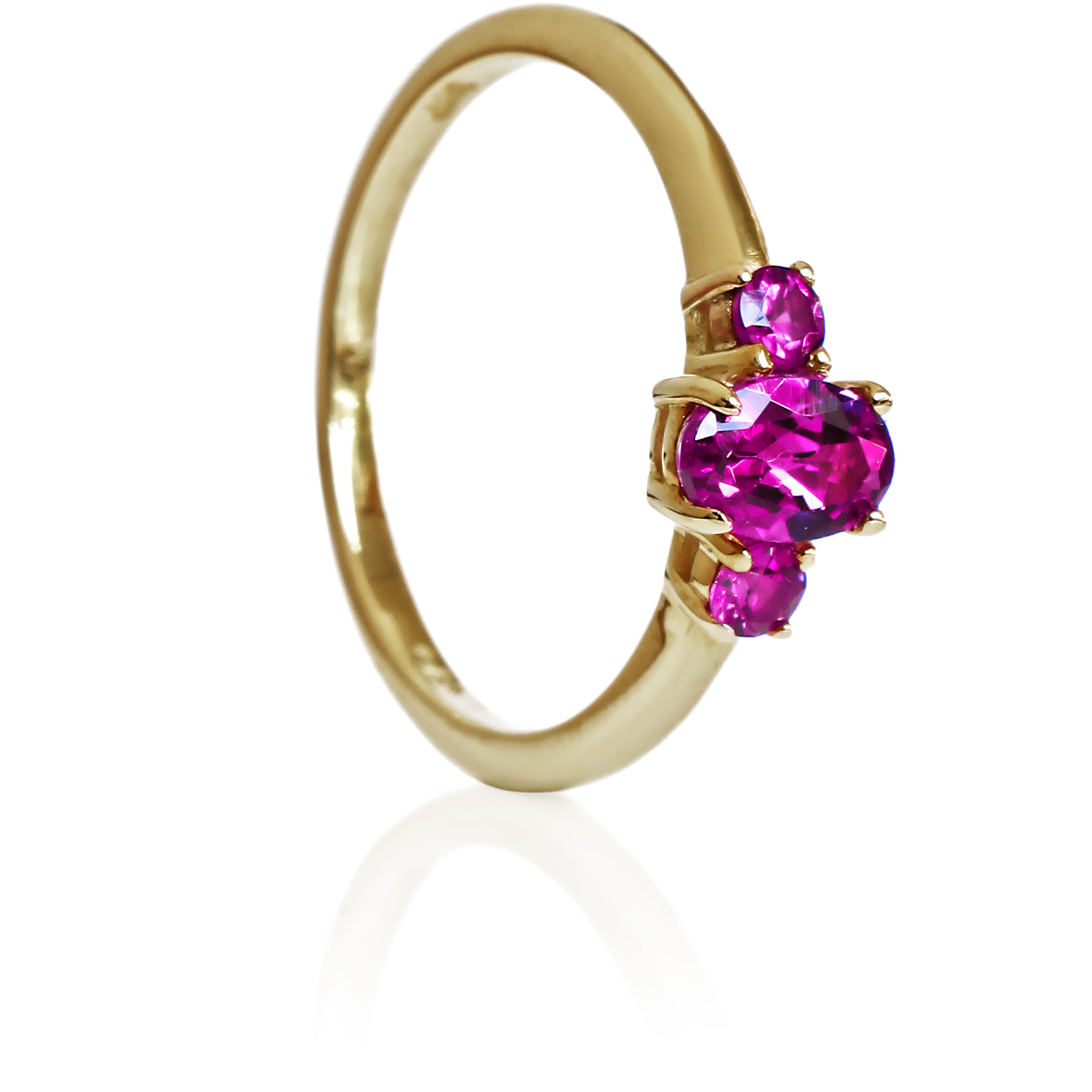A product photo of a dainty and elegant yellow gold ring with a stunning trio of grape garnets sitting against a white background. The largest of the stones sits in the centre, an oval 6x4mm grape garnet - hugged by two smaller circular warm purple stones on either side.