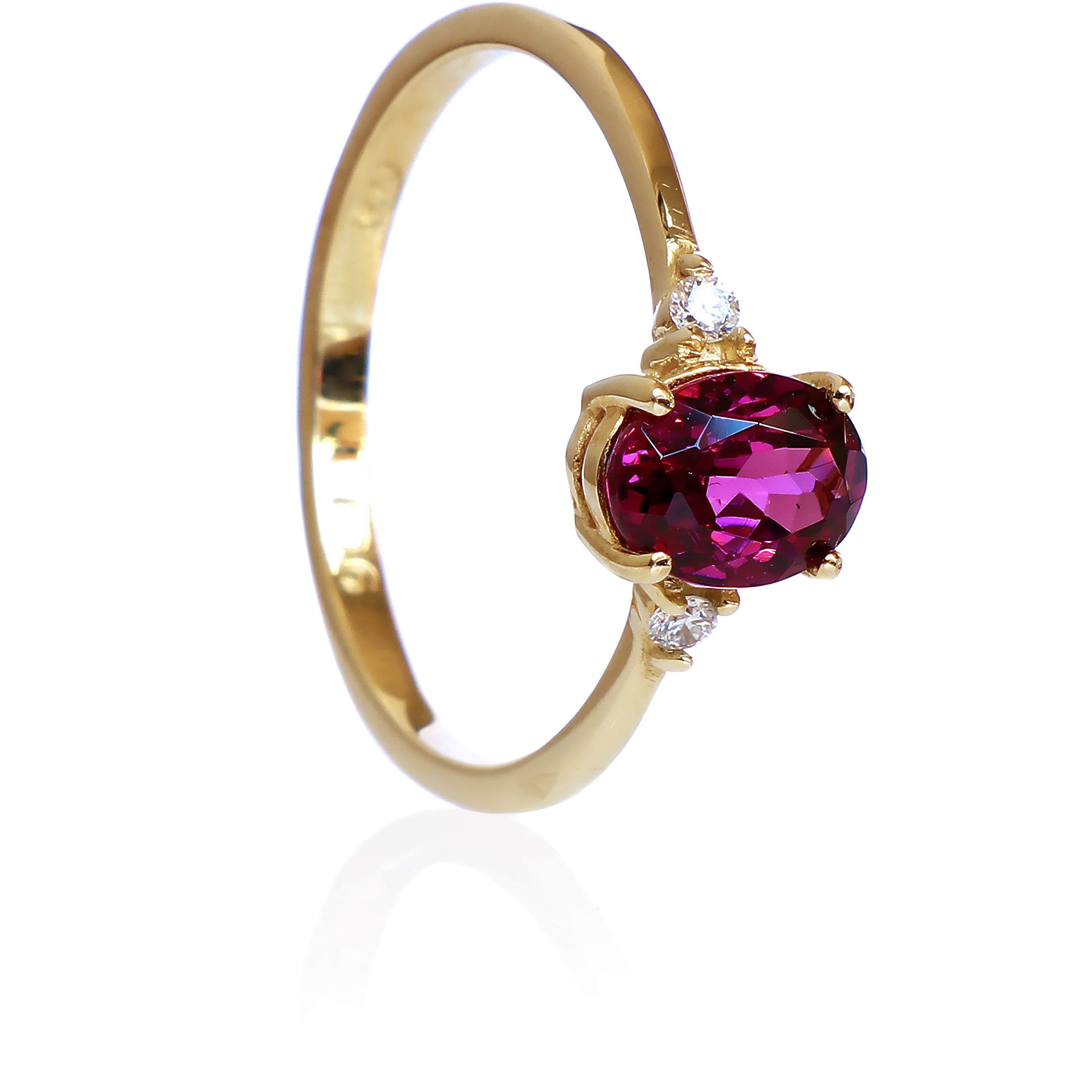 A product photo of a yellow gold grape garnet ring sitting against a white background. The gold band is plain and smooth, and the centre oval-cut warm purple garnet stone is framed by a single white diamond on either side.