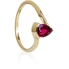 A product photo of a yellow gold rhodalite ring sitting against a white background. The gold band is plain and smooth, and curves to meet at the top and bottom of a large, 7x5mm pear shaped rhodalite centre stone - holding it in place.