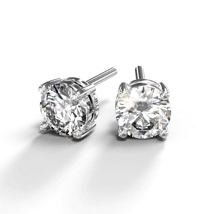A turntable video of a pair of 9 karat white gold lab diamond stud earrings sitting in the sun on a white textured background. The brilliant, colourless half pointer round diamonds measure 5mm across, and are held in place by a simple 4-claw setting.