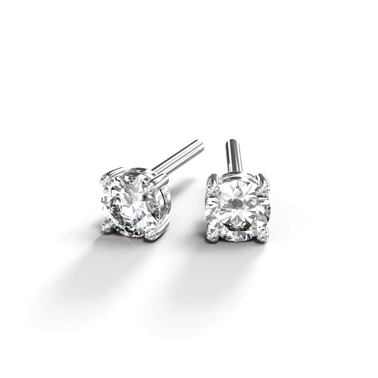 A turntable video of a pair of 9 karat white gold lab diamond stud earrings sitting in the sun on a white textured background. The brilliant, colourless half pointer round diamonds measure approximately 3mm across, and are held in place by a simple 4-claw setting.