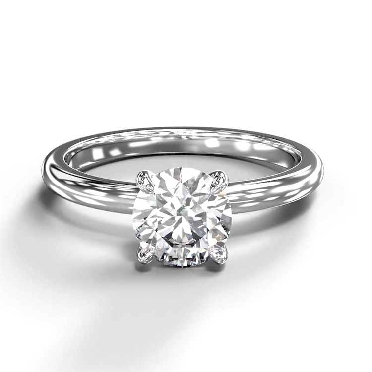 
            
                Load image into Gallery viewer, A turntable video of a 14 karat white gold lab diamond solitaire engagement ring sitting in the sun on a white textured background. The brilliant, colourless 1 carat round-cut diamond measures 6.3mm lengthwise, and is held in place by 4 delicate claws in a prong setting.
            
        