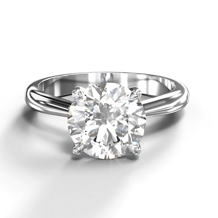 A turntable video of a 14 karat white gold lab diamond solitaire engagement ring sitting in the sun on a white textured background. The brilliant, colourless 2 carat round-cut diamond measures over 8mm across, and is held in place by 4 delicate claws in a high-profile cathedral setting in the middle of the thick, tapered band.
