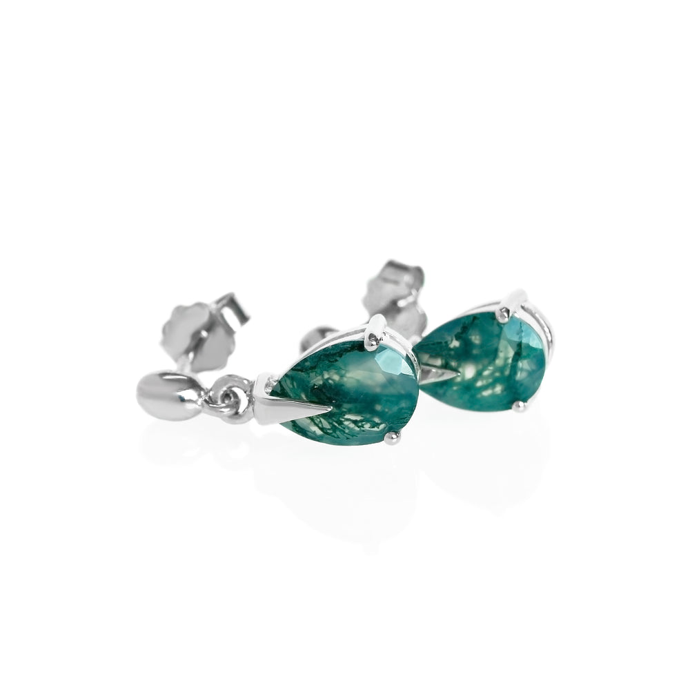 A product photo of a pair of 9x7mm pear-shaped moss agate drop earrings in 925 sterling silver on a white background. The gemstones have a cool white milky colour, with deep, swirling green natural inclusions, and are each held in place with a singular sharp prong, giving them a severe yet elegant appearance.