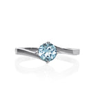 A product photo of a curved-band silver solitaire ring with a pale blue aquamarine centre stone sitting on a white background.