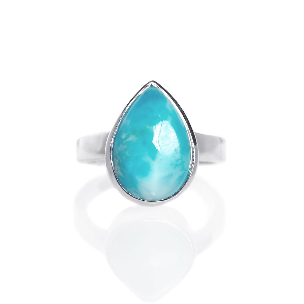 
            
                Load image into Gallery viewer, A product photo of a silver Larimar ring on a white background. The band is tall and thick. The 12x8mm pear cabochon Larimar stone has dappled white and light blue patterning, similar to water reflections at the bottom of a pool. The stone is set in a thick silver bezel setting.
            
        