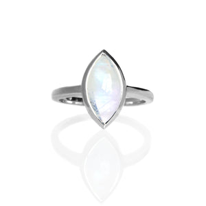 A product photo of a silver moonstone solitaire ring on a white background. The 12x6mm marquise-shaped cabochon moonstone is uniquely translucent, with a light base tone and milky white inclusions. The stone is held in place with a silver bezel setting.