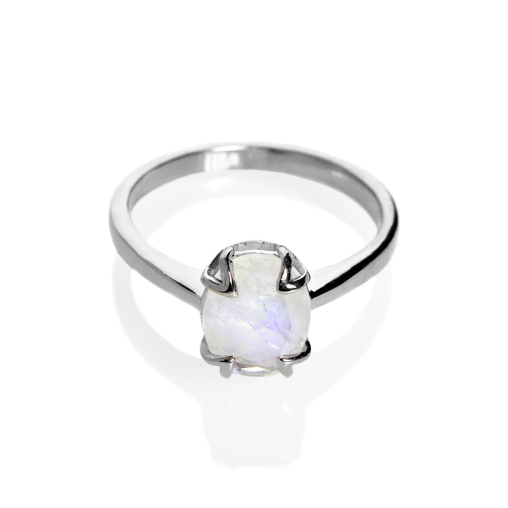 
            
                Load image into Gallery viewer, A product photo of a silver moonstone solitaire ring on a white background. The 9x7mm oval faceted moonstone is uniquely translucent, with an indigo sheen and milky inclusions. The stone is held in place with 4 v-shaped silver claws.
            
        