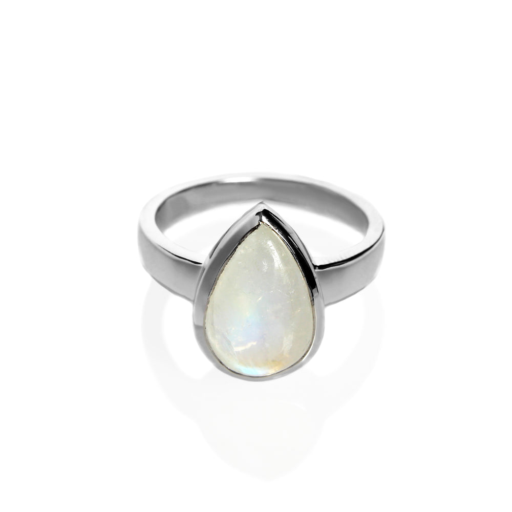 A product photo of a silver moonstone ring on a white background. The band is tall and thick. The 12x8mm pear cabochon moonstone has a blue/purple sheen, with unique milky natural inclusions. The stone is set in a thick silver bezel setting. 