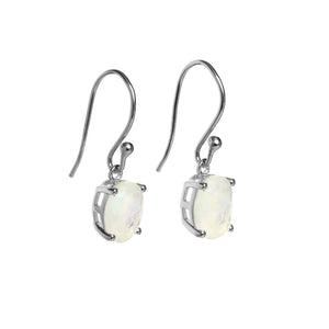 
            
                Load image into Gallery viewer, A product photo of a pair of sterling silver natural moonstone drop earrings suspended against a white background. The drop earrings feature shepherd hooks, and the 9x7mm oval-shaped faceted moonstones are held in place by 4 delicate silver claws.
            
        