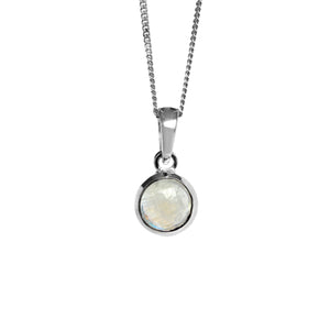 A product photo of a round-shaped cabochon moonstone pendant suspended by a chain over a white background. The moonstone gem has a smooth, rounded surface, with milky natural inclusions and a blue moonstone sheen. It is held in place by a thick silver frame.