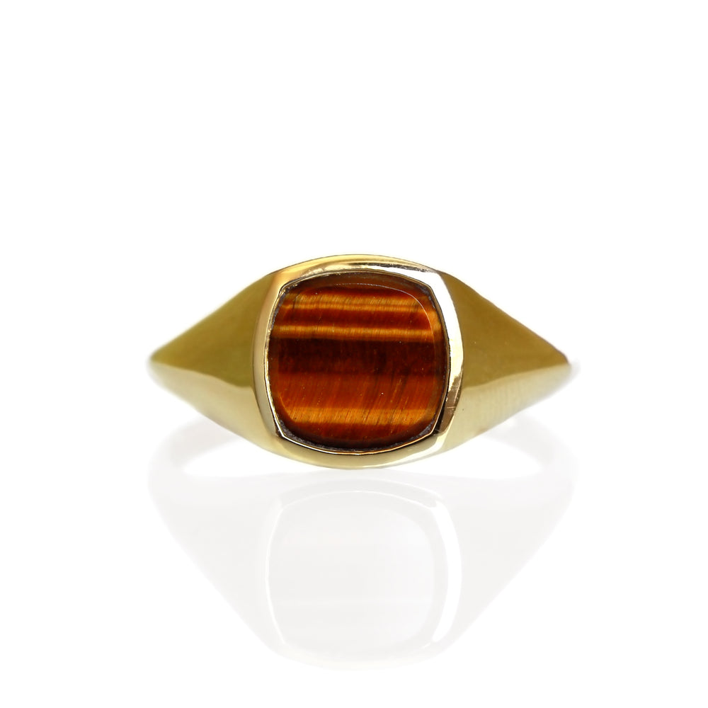 A product photo of a mens' signet ring made of 9k yellow gold on a white background. The face of the ring is a 8x8mm squared-cushion Tiger's Eye shard that transitions to a thick rounded gold band.