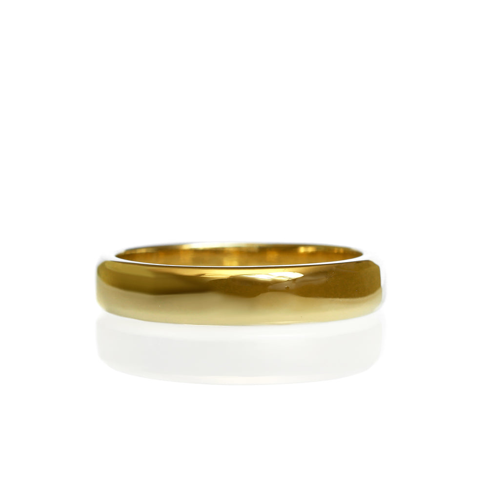 A product photo of a mens' ring made of 9k yellow gold on a white background. The band is softly bevelled in a D shape.