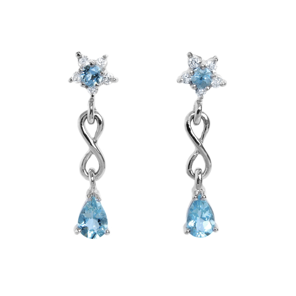 A product photo of a pair of aquamarine stud drop earrings in 9k white gold over a white background. The earrings are composed of a thick frame of white gold in the shape of a tear, swooping downwards to meet on either side of a gold-encased round aquamarine gemstone. Where the frame and bezel-setting meet are 3 dainty detailing diamonds on either side.