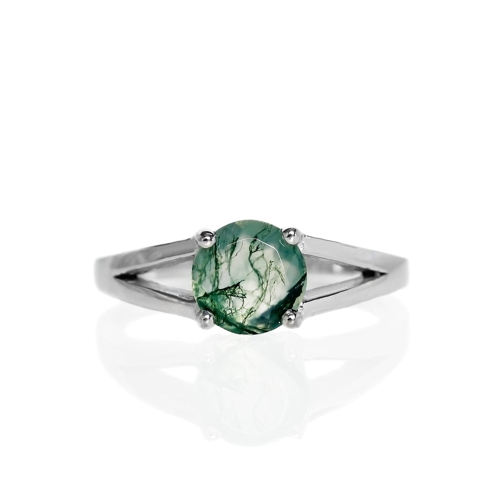 A product photo of moss agate solitaire ring in solid 925 sterling silver on a white background. The band is split into two prongs, meeting on either side of the 7mm round faceted moss agate jewel.