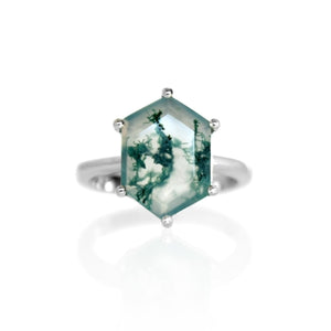 A product photo of an impressively bold statement silver moss agate ring on a white background. The ring features a large 14x10mm vertically-oriented hexagonal stone with a cloudy base and bold surface inclusions, held in place by six silver claws, one on each of its edges.