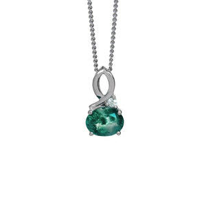 A product photo of a silver moss agate and moissanite necklace suspended against a white background. The moss agate is horizontally-oriented and held in place by 4 silver claws, connecting the gemstone to its unique bail, consisting of looping silver detailing and a single tiny moissanite detail where one loop intersects.