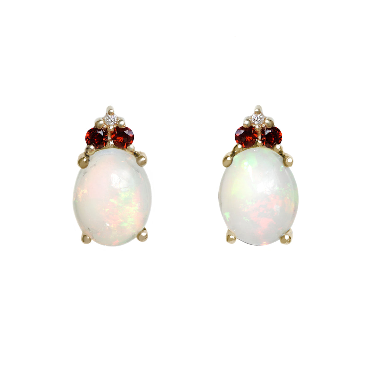 A product photo of a pair of solid 9 carat yellow gold rainbow fire opals and natural garnet and diamond trio cluster earrings upon a white background. The large oval rainbow opal gemstones stand in stark contrast to the little clusters of two white sparkling diamond stone and one garnet on top of each.