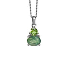 A product photo of a silver moss agate and green peridot necklace suspended against a white background. The horizontally-oriented moss agate stone is held in place by 4 pairs of claws at its top and bottom, with a 5mm warm, grass green peridot birthstone connecting the stone to the rest of the pendant. It is suspended by a simple silver chain.
