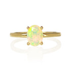 A product photo of an oval yellow gold solitaire ring on a white background. The band is rounded and smooth, and the 8x6mm faceted hydrophane Ethiopian opal gemstone, glinting in the light, is held in place by 4 delicate golden claws.