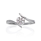 A product photo of a moissanite ring in 9k white gold on a clear white background. A simple crescent band hugs the top and bottom of the 7-jewel cluster of reflective moissanite gems in the centre.