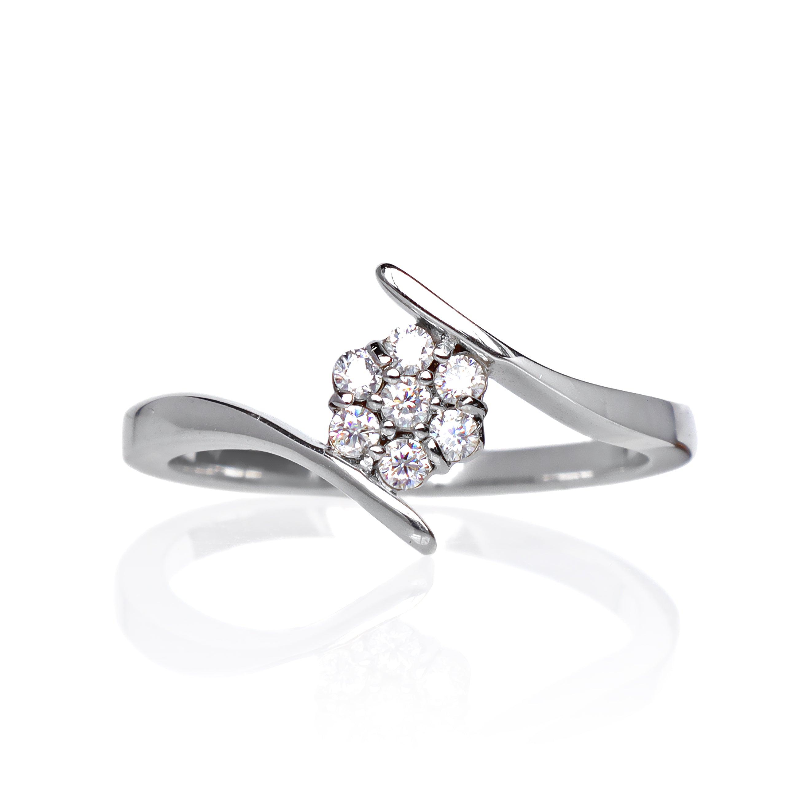 A product photo of a moissanite ring in 9k white gold on a clear white background. A simple crescent band hugs the top and bottom of the 7-jewel cluster of reflective moissanite gems in the centre.