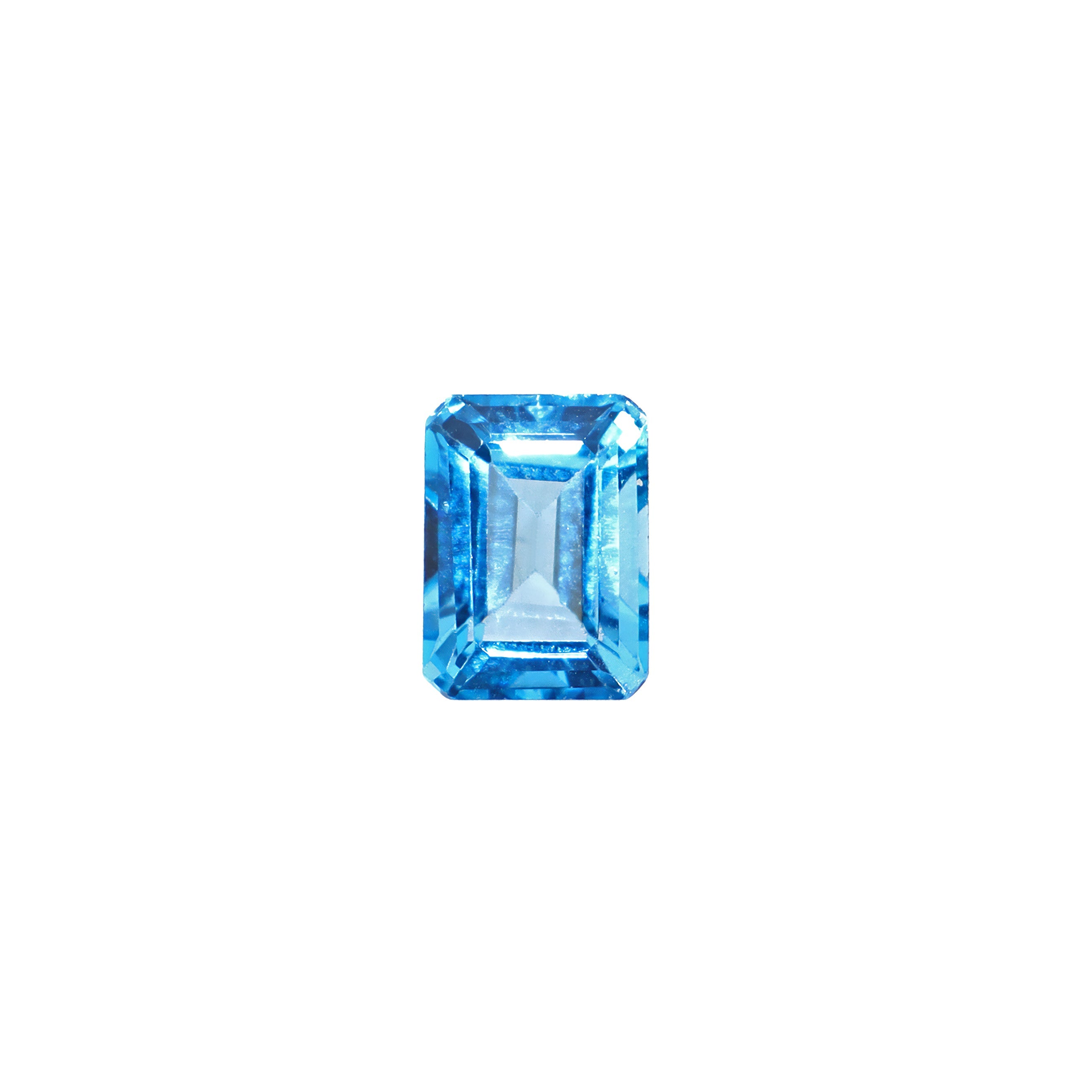A loose 8x6mm emerald Swiss blue topaz gemstone on a white background. This brilliant, saturated blue topaz, November's birthstone, is perfect for creating custom fine jewellery: including engagement rings, cocktail rings, or a striking birthstone pendant for a loved one born in November.