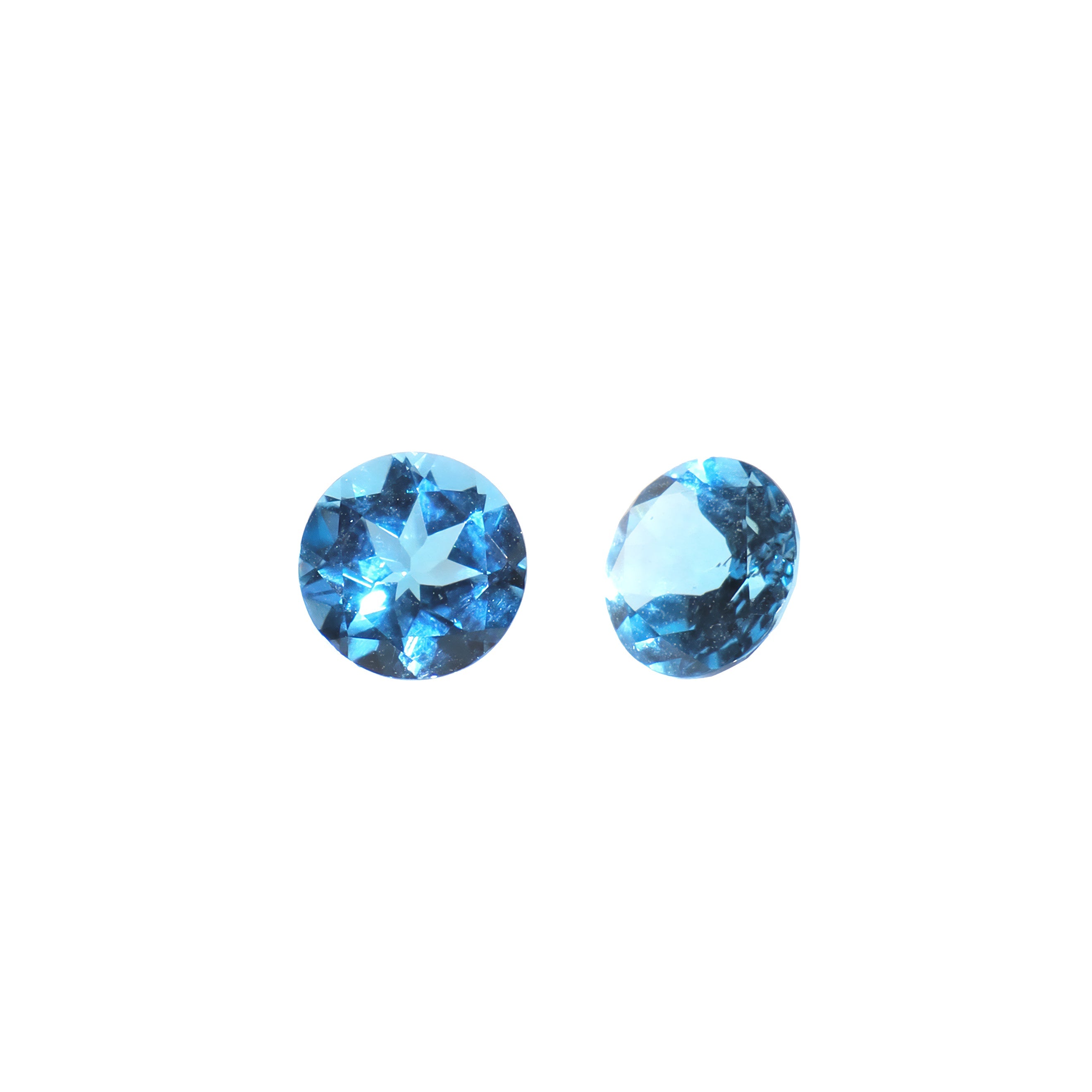 A pair of 6mm round Swiss blue topaz gemstones on a white background. The stones are perfectly-matched in both size and vibrant blue hue, and are ideal for use in a bespoke pair of birthstone earrings, or as a gift to two people with a November birthday.