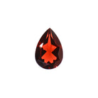 A loose 12mm trilliant cut red Mozambican garnet gemstone on a white background. This brilliant, richly coloured garnet, January's birthstone, is perfect for creating custom fine jewellery: including engagement rings, cocktail rings, or a striking birthstone pendant for a loved one born in January. The colouring is a deep, rich scarlet red.
