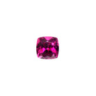 A loose 7mm cushion cut deeply-coloured grape garnet gemstone on a white background. This large, brilliantly cut natural grape garnet displays a vibrant warm purple, winelike hue, perfect for use in bespoke luxury jewellery designs. An excellent choice for a January birthstone pendant, or as an addition to one's personal gemstone collection.