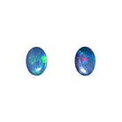 A product photo featuring a pair of 7x5mm oval opal doublets on a white background. These matched stones display a vibrant play-of-colour with coordinated flashes of green and blue. Perfect for bespoke stud earrings or a matching jewellery set. A high-impact, affordable October birthstone option for custom-made gifts.