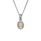A product photo from  showing a silver Ethiopian rainbow opal pendant on a fine twist chain against a white background. The vertically-oriented, oval opal flashes with fiery orange, yellow, and green tones. It is secured by four discreet claws and surrounded by a scalloped, floral-inspired halo set with small, glittering white accent stones. The pendant hangs from a polished, classic tapered silver bail.