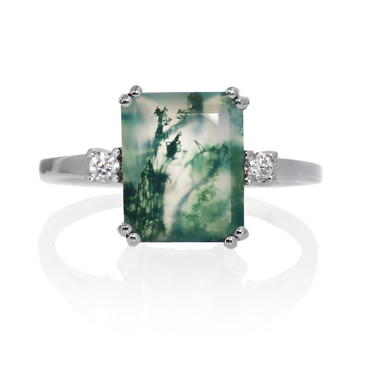 A product photo of a sterling silver ring with a rectangular, 10x8mm emerald-cut green moss agate center stone. The agate features distinct moss-like patterns and is flanked by a small, brilliant-cut white moissanite on each side of the band, set against a white background.
