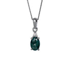 A product photo of a sterling silver moss agate and moissanite necklace sitting against a white background. The beautifully unique moss agate stone is held in place by 4 pairs of claws at its top and bottom, with a single white moissanites connecting the stone to the rest of the pendant. It is suspended by a simple sterling silver chain.