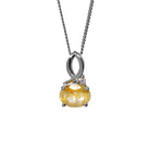 A product photo of a silver golden rutilated quartz and moissanite necklace suspended against a white background. The golden rutilated quartz is horizontally-oriented and held in place by 4 silver claws, connecting the gemstone to its unique bail, consisting of looping silver detailing and a single tiny moissanite detail where one loop intersects.
