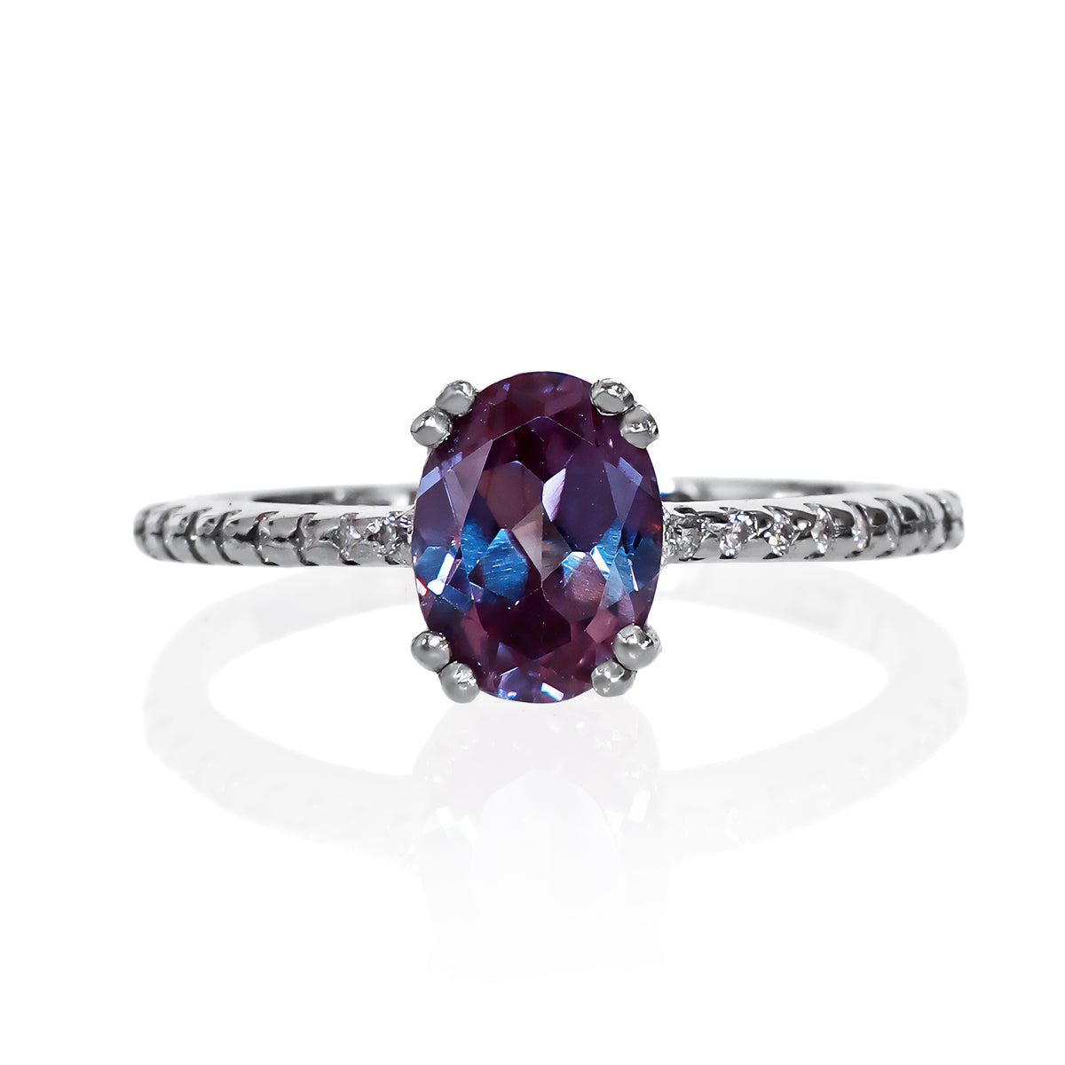 A product photo of a silver lab alexandrite engagement ring on a white background. The ring draws from contemporary alternative styling with the 8x6mm lab alexandrite centre stone, while calling back to the pavÃ© engagement styles of the past with its moissanite-embedded band.