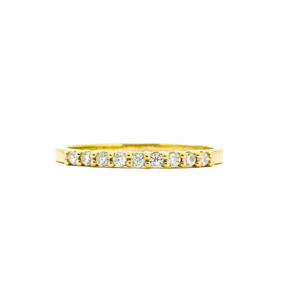 A product photo of a moissanite half-eternity ring in yellow gold. 9 white moissanite gems embedded in the band detail about a third of the ring's length before smoothing out into simple yellow gold.