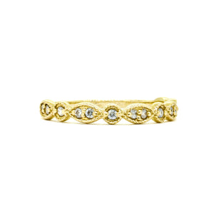 A product photo of an ornate moissanite ring in 9k yellow gold. Oval gold frames adorned with two small moissanite gems each alternate with circular gold frames adorned with singular moissanite gems, making up the ring for about half of its length before smoothing out into a simple flat yellow gold band. 
