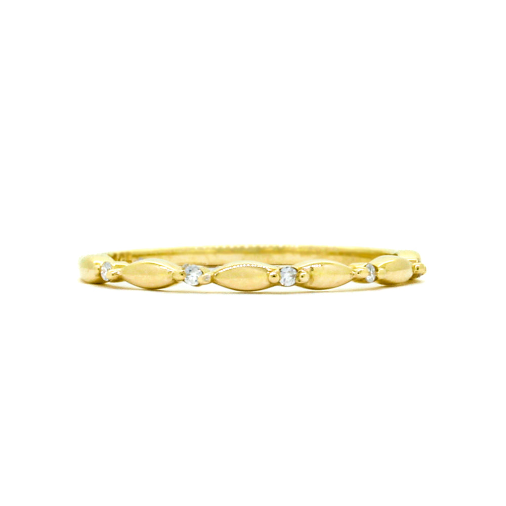 A product photo of a moissanite half-eternity ring in 9k yellow gold sitting on a clear white background. Elongated oval shaped detail about half of the band's length, separated by 5 delicate circle-cut moissanite jewels.