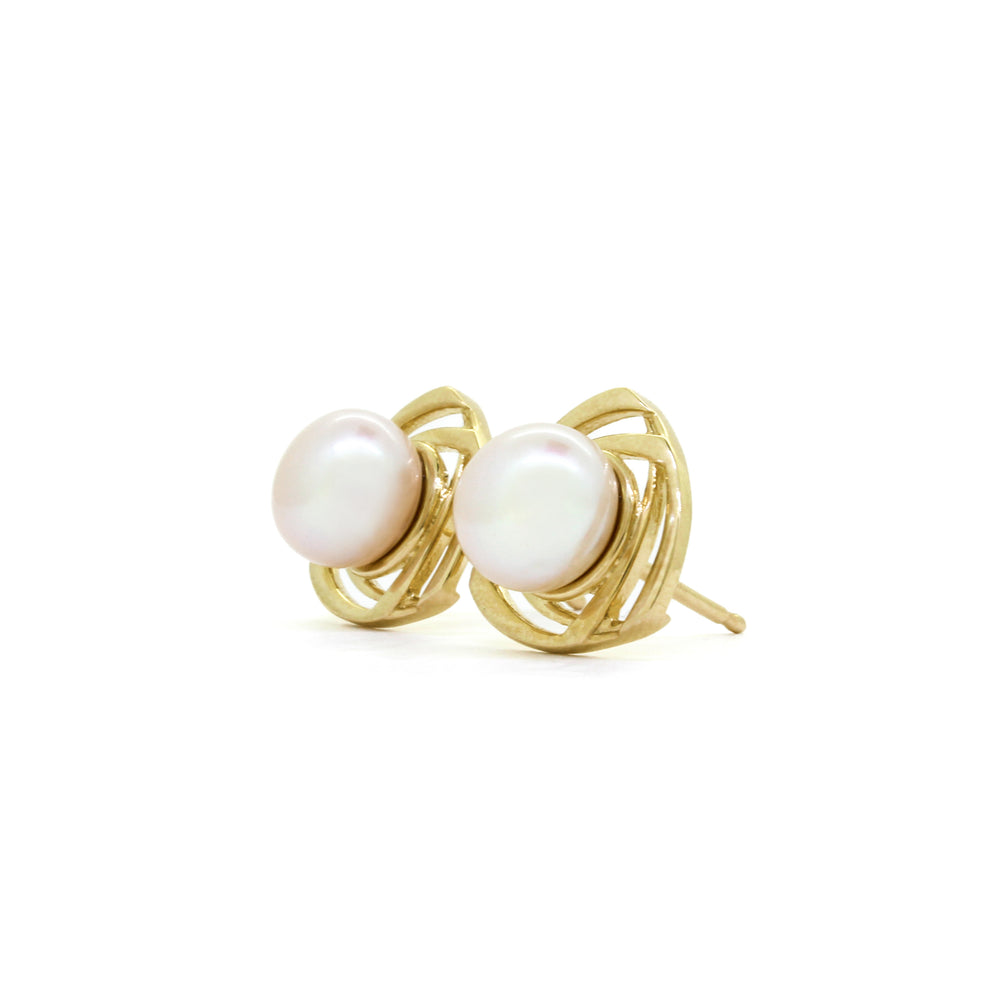 A product photo of ornate white pearl earring studs with detailed yellow gold backs on a white background.