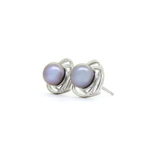 A product photo of a ornate steel grey pearl earring studs with detailed white gold backs on a white background.