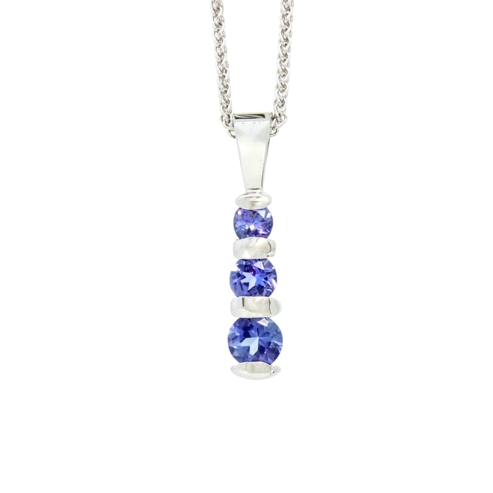 A product photo of a silver tanzanite pendant made up of 3 stones stacked vertically, descending from smallest to largest. The pendant is suspended by a silver chain against a white background.
