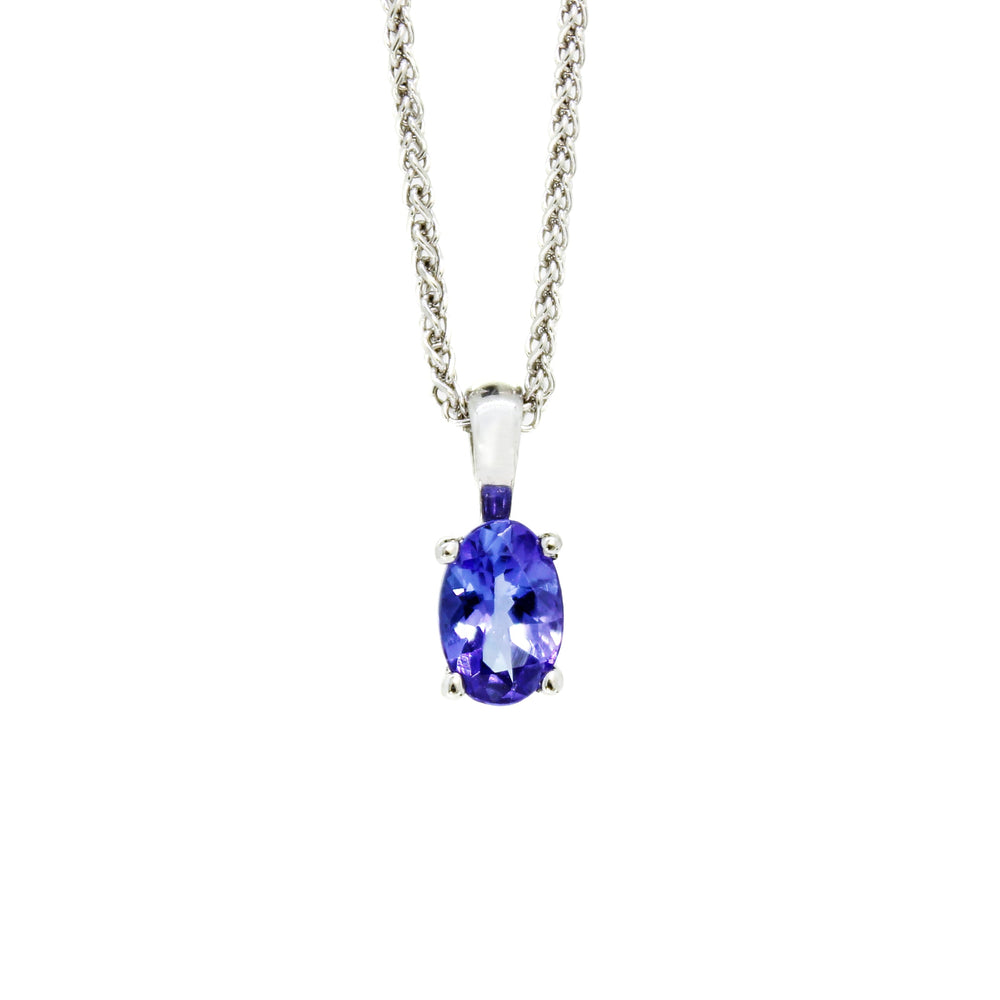 A product photo of a silver pendant with a deep blue tanzanite centre stone. The stone is held in place by 4 delicate silver claws.