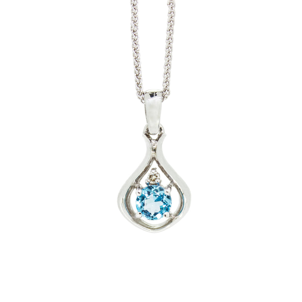A product photo of a silver pendant with a light blue topaz centre stone. The stone sits at the base of a silver teardrop shape, with a small diamond positioned above it. The pendant is suspended by a silver chain against a white background.